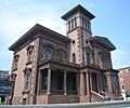 Low-angle photograph of Victoria Mansion in urban surroundings.