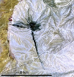 Shiprock and associated dikes taken by NASA in 2006 with the Terra satellite. The colors shown represent infrared wavelengths: Lush vegetation appears bright red, while different kinds of rock with less vegetation appear in shades of gray, black, and tan.[17]