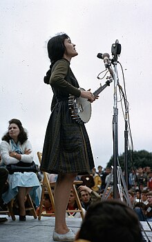 West performing at Newport Folk Festival, 1964