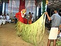 Channel/medium tying the siri — palm leaves skirt around his waist