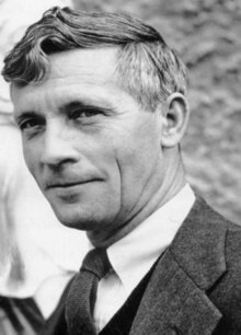 Head-and-shoulders portrait of a middle-aged white man in a formal suit, jacket and waistcoat. He is cleanly shaven with short, styled hair.