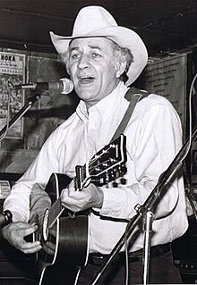 man playing guitar and singing into microphone