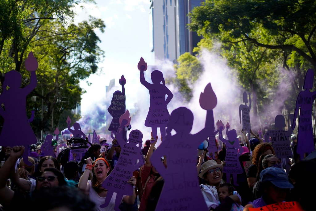 Women, many holding up purple silhouette cutouts that depict the anti-monument "Mujeres que luchan" or women who fight, march to the Zocalo to mark International Day for the Elimination of Violence against Women, in Mexico City, Nov. 25, 2023.