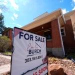 A "FOR SALE" sign in front of a home