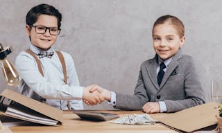 Portrait of smiling caucasian children shaking hands and looking at camera at workplace — Photo by VikaOvcharenko