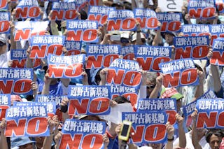 Protesters raise placards during a rally to oppose the transfer of a key U.S. military base within the prefecture, at a baseball