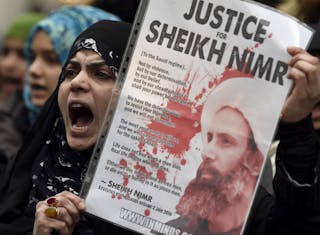 Protester holds a placard during a demonstration against the execution of Shi'ite cleric Sheikh Nimr al-Nimr in Saudi Arabia, ou