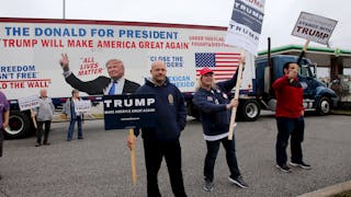 Supporters of U.S. Republican presidential candidate Donald Trump hold up signs to drivers as they pass by on Super Tuesday in M