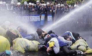 Police use water cannon to disperse demonstrators protesting construction of fourth nuclear plant, in front of Taipei Railway st