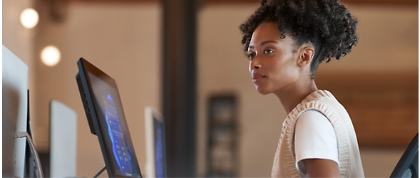 A woman is sitting at a desk in front of a computer.