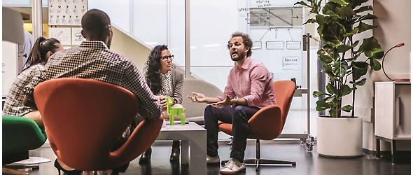 A group of people sitting around a table in an office.