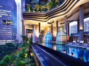 una piscina de hotel en un edificio con gente dentro en PARKROYAL COLLECTION Pickering, Singapore en Singapur