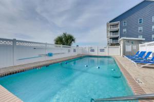 a swimming pool with blue chairs next to a building at The Beach Is Back in Myrtle Beach