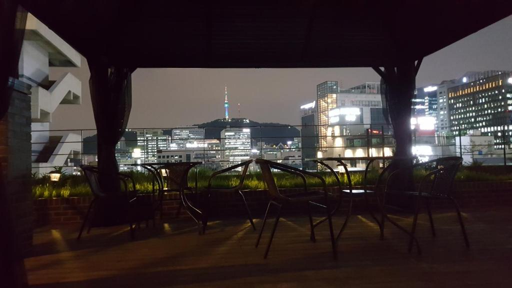 grupa krzeseł siedzących na balkonie w nocy w obiekcie Grid Inn Hotel w Seulu