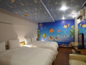 a bedroom with two beds and an aquarium wall at Day Chen Hotel in Yilan City