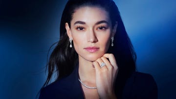 close up of a woman wearing a diamond ring, diamond necklace and diamond earrings