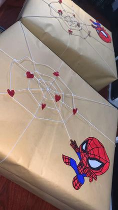 two wrapped presents with spiderman designs on them