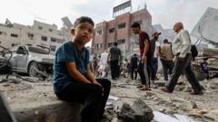 加沙儿童坐在被炸毁房屋前