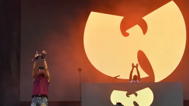 RZA performs in front of a Wu-Tang Clan sign