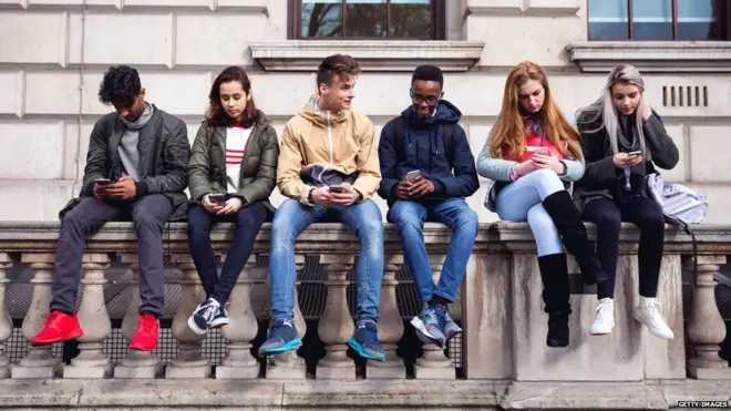 Students sitting on a wall