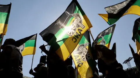 ANC supporters carry party flags in Johannesburg, South Africa. Photo: May 2024