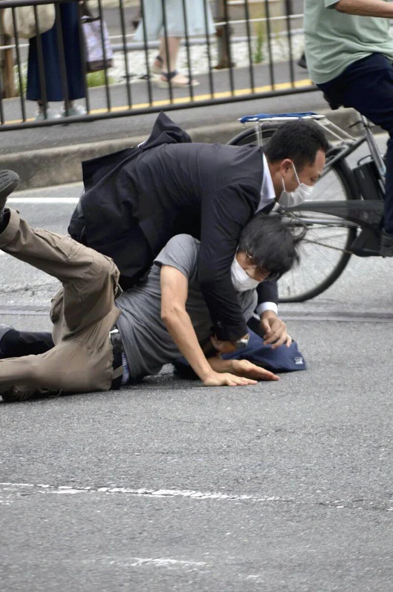 日本前首相安倍晉三7月8日遭槍擊，嫌犯山上徹也（灰衣者）當場被逮捕。（Yomiuri Shimbun via 美聯社）