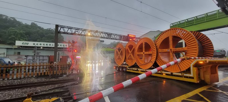 新北警方7日表示，1輛拖板車6日行經樹林區的平交道時卡在鐵軌中，平交道柵欄也剛好放下來，雙線都有火車即將經過，情況危急，幸經駕駛按下警示鈕，巡邏員警找來堆高機協助脫困，才避免可能發生的交通意外。（警方提供）中央社記者黃旭昇新北傳真  112年9月7日