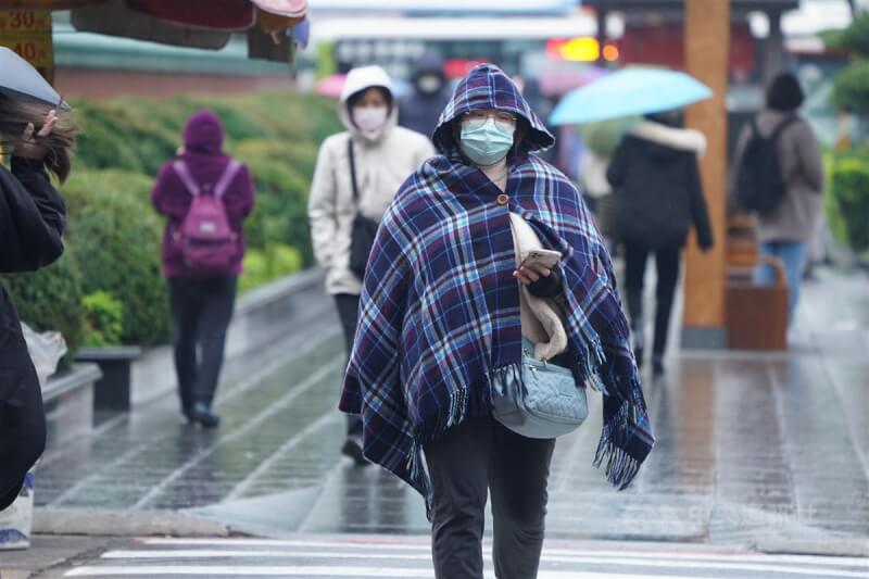 圖為台北市中山區民眾披著毛��禦寒。（中央社檔案照片）