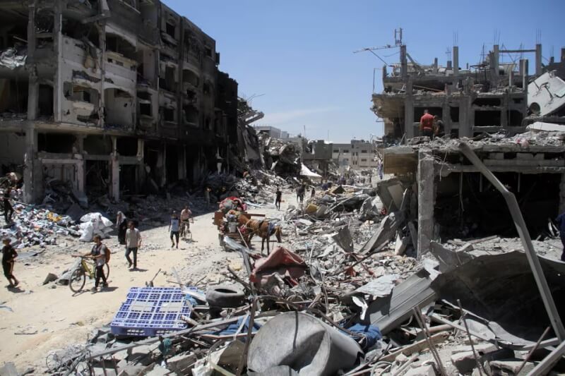 巴勒斯坦民眾5月31日在以色列攻擊加薩走廊北部的賈巴利亞難民營連忙撤離，有部分人查看建物毀損情況。（路透社）