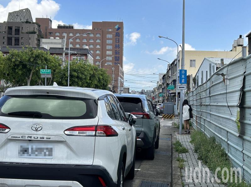 台中市高鐵重劃區烏日區健行路人行道窄，又有路燈基座等擋道，迫使行人側身貼牆通過。記者趙容萱／攝影