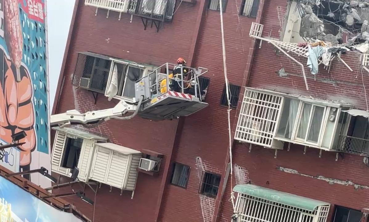 花蓮天王星大樓9日拆除作業時，發現一隻橘白貓卡在鐵窗，看起來非常緊張；消防局調派雲梯車前往救援，把貓咪救下來交給飼主。（中央社）