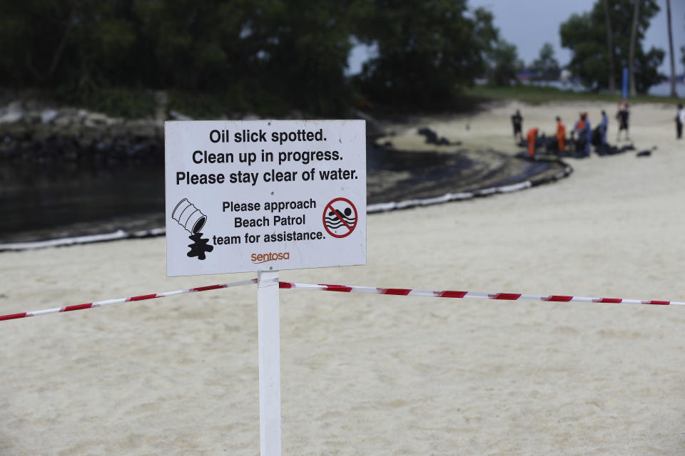 A signboard warning of oil spill is seen along Sentosa's Tanjong Beach area in Singapore, Sunday, June 16, 2024. An oil spill caused by a dredger boat hitting a stationary cargo tanker has blackened part of Singapore’s southern coastline, including the popular resort island of Sentosa, and sparked concerns it may threaten marine wildlife. (AP Photo/Suhaimi Abdullah)