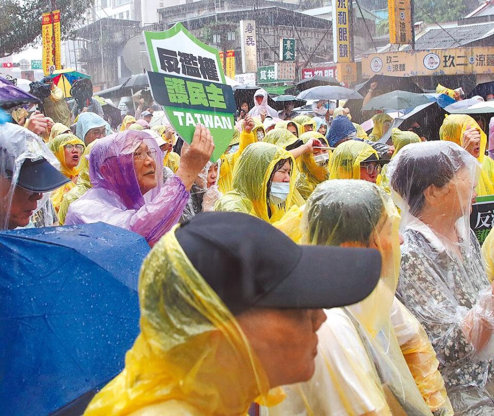 民進黨16日在台北市松山慈祐宮舉行「反濫權 護民主」說明會，宣講時，下起大雨，參與的民眾穿著雨衣，一起喊口號。（劉宗龍攝）
