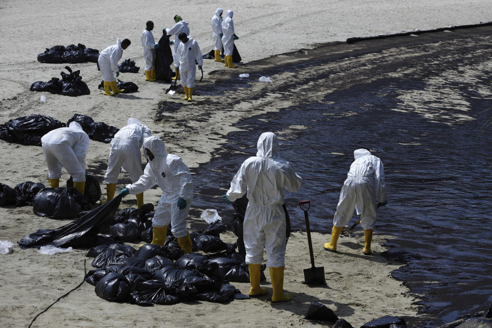 Workers clean oil spill along Sentosa's Tanjong Beach area in Singapore, Sunday, June 16, 2024. (AP Photo/Suhaimi Abdullah)