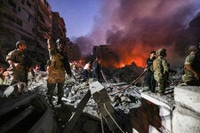 Lebanese army soldiers gather over the rubble of a levelled buildings as people flight the flames, following Israeli air strikes in the Haret Hreik neighbourhood of Beirut’s southern suburbs on on Friday.