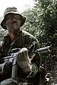 One of combat control team members, armed with a GAU-5 assault rifles, maneuvers down a river by a boat during training