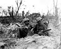 Marine Pfc. Douglas Lightheart (right) cradles his 30-cal. machine gun in his lap, while he and his buddy Pfc. Gerald Churchby take time out for a cigarette, Peleliu, September 14, 1944.