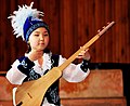 A young girl plays the Komuz, a Kyrgyz traditional instrument