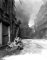 German woman carrying a few possessions runs from burning building in Siegburg, Germany. Fire started by Nazi saboteur. April 13, 1945