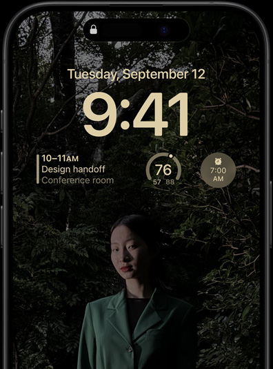 The Always-On display of iPhone 15 Pro showcasing a Lock Screen with a calendar widget, a weather widget and an alarm widget