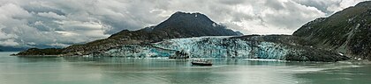 Navio Safari Endeavor (71 m de comprimento e com até 88 convidados, mais 37 tripulantes) em frente à geleira Lamplugh, Parque Nacional e Reserva da Baía dos Glaciares, Alasca, Estados Unidos. A geleira Lamplugh tem 13 km de extensão e seu término está localizado na enseada Johns Hopkins, 2,3 km a oeste de Ptarmigan Creek e 122 km a noroeste de Hoonah. Em 28 de junho de 2016, uma montanha de 1 200 metros de altura desmoronou na geleira Lamplugh, causando um deslizamento de terra, rochas e detritos sobre a geleira. O deslizamento deixou um campo de destroços de 9 km de comprimento em sua superfície. (definição 11 700 × 2 668)