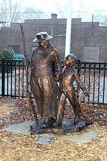Uma estátua de metal segurando a mãe de uma criança