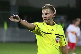 Árbitro de fútbol con el silbato en la mano