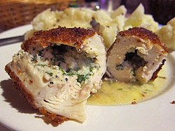 Pieces of chicken Kiev in butter sauce spread on a plate