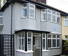 A grey two-story building, with numerous windows visible on both levels