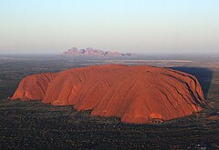Uluru (Ayers Rock) i förgrunden med Kata Tjuta (The Olgas) i bakgrunden
