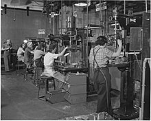 Women work in a west coast United States airplane factory on drill presses in 1942.