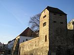 Stadsmuren i det judiska kvarteret. Byggnaden med det pyramidformade taket är en av Europas äldsta bevarade synagogor (1400-talet).