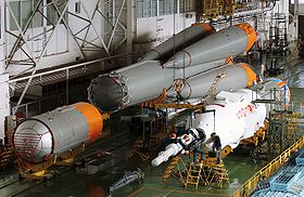 Na fotografiji je vidljivo spajanje dijelova rakete Sojuz. Prvi i drugi stupanj su već spojeni, a treći stupanj se može vidjeti kao bijeli objekt desno od tijela rakete..