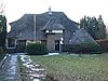 Villa met aangebouwde schuur met elementen uit de Amsterdamse Schoolstijl en de Engelse landhuisstijl